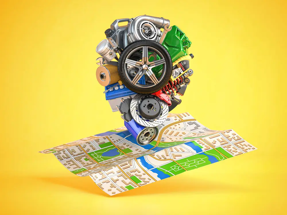 Car parts — wheels, brake discs, filters and a turbocharger — stacked on an open road map